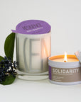 Luxury Solidarity soy candle with lilac buds, green leaves, and cool earth, handcrafted in Illinois, resilience-themed glass vessel by Labyrinth Made Goods at brixbailey.com