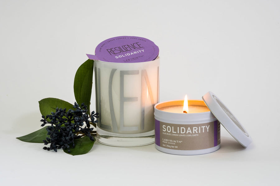 Luxury Solidarity soy candle with lilac buds, green leaves, and cool earth, handcrafted in Illinois, resilience-themed glass vessel by Labyrinth Made Goods at brixbailey.com