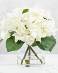 Faux hydrangea centerpiece arrangement in glass vase