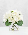 Faux hydrangea centerpiece arrangement in glass vase
