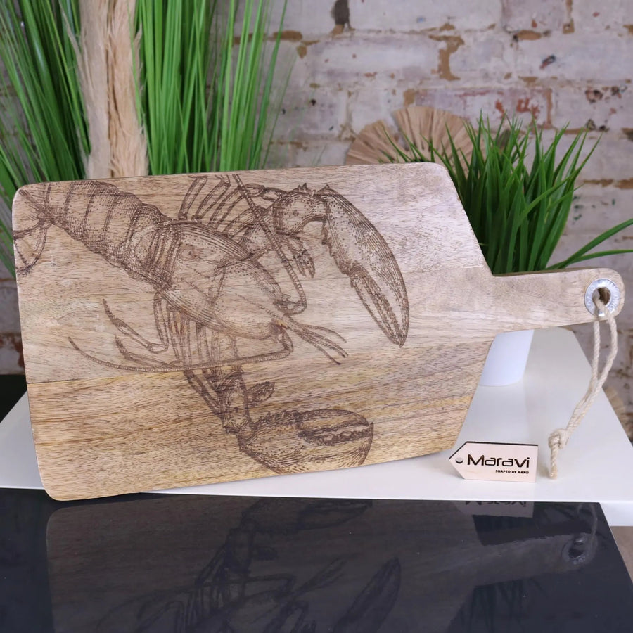 Luxury handcrafted fish serving platter board, premium mango wood with intricate lobster or fish engraving, stylish coastal kitchenware by Maravi at brixbailey.com