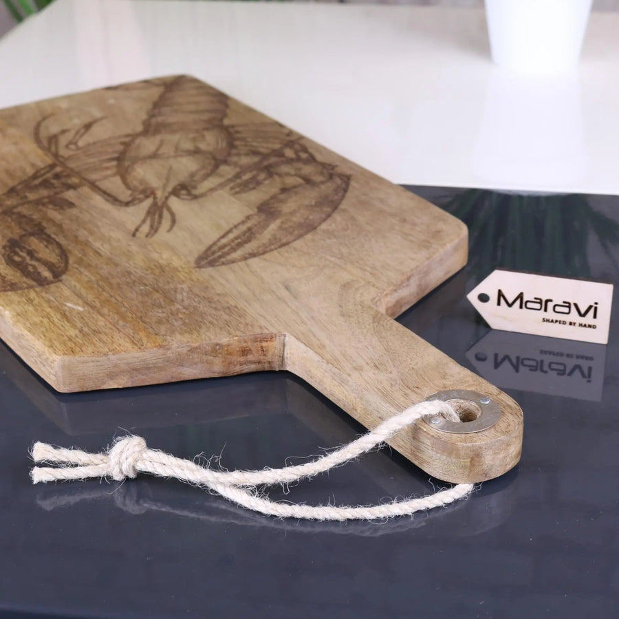 Luxury handcrafted fish serving platter board, premium mango wood with intricate lobster or fish engraving, stylish coastal kitchenware by Maravi at brixbailey.com