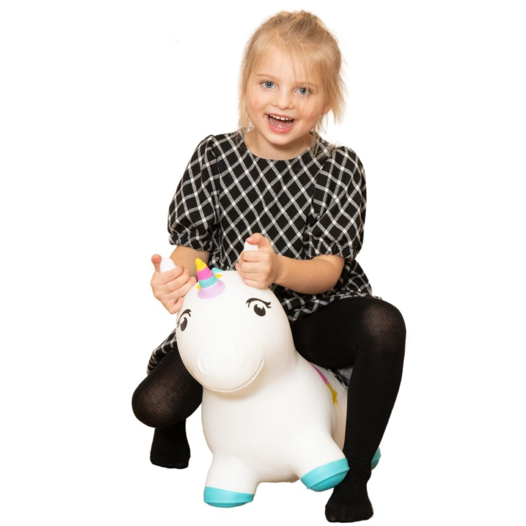 confident toddler bouncing on a vibrant unicorn hopper toy indoors