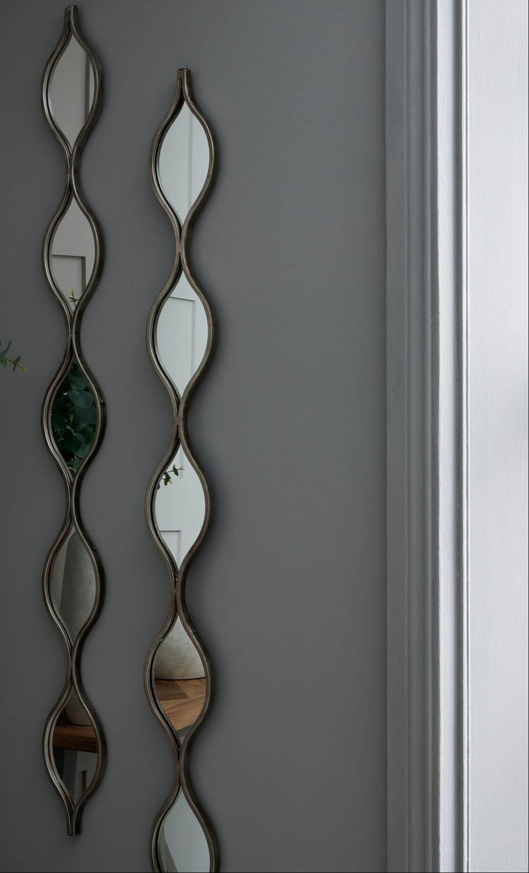 Decorative hanging silver mirror with slim frame, 146cm tall, reflecting light for modern or vintage decor by Sostter at brixbailey.com