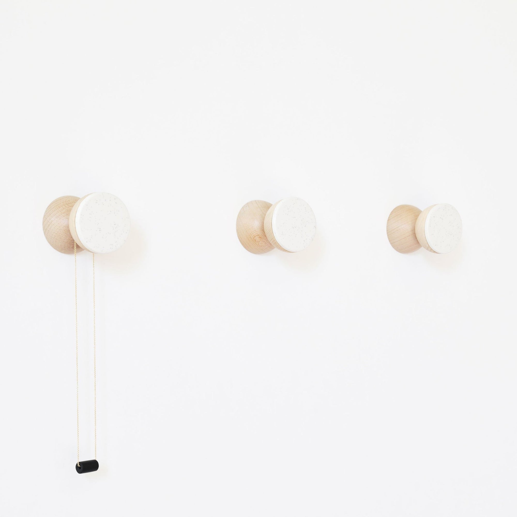 bold modern white sand ceramic and beech wood wall hook on a clean minimalist background