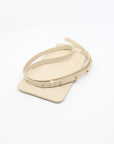 elegant beige leather phone bag with a gold-tone adjustable strap, shown in soft morning light