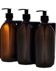 Three Kuishi amber glass bottles with black pump dispensers on a white background