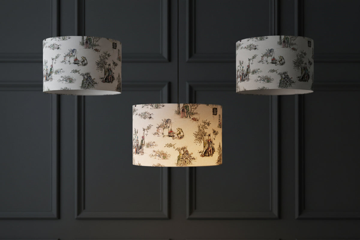 Three Brix + Bailey urban toile lampshades hanging at different heights against dark charcoal panelling, the centre one lit