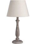 Rustic table lamp with whitewashed wood base and linen shade, warm beige tones for cozy ambient lighting. by Sostter at brixbailey.com