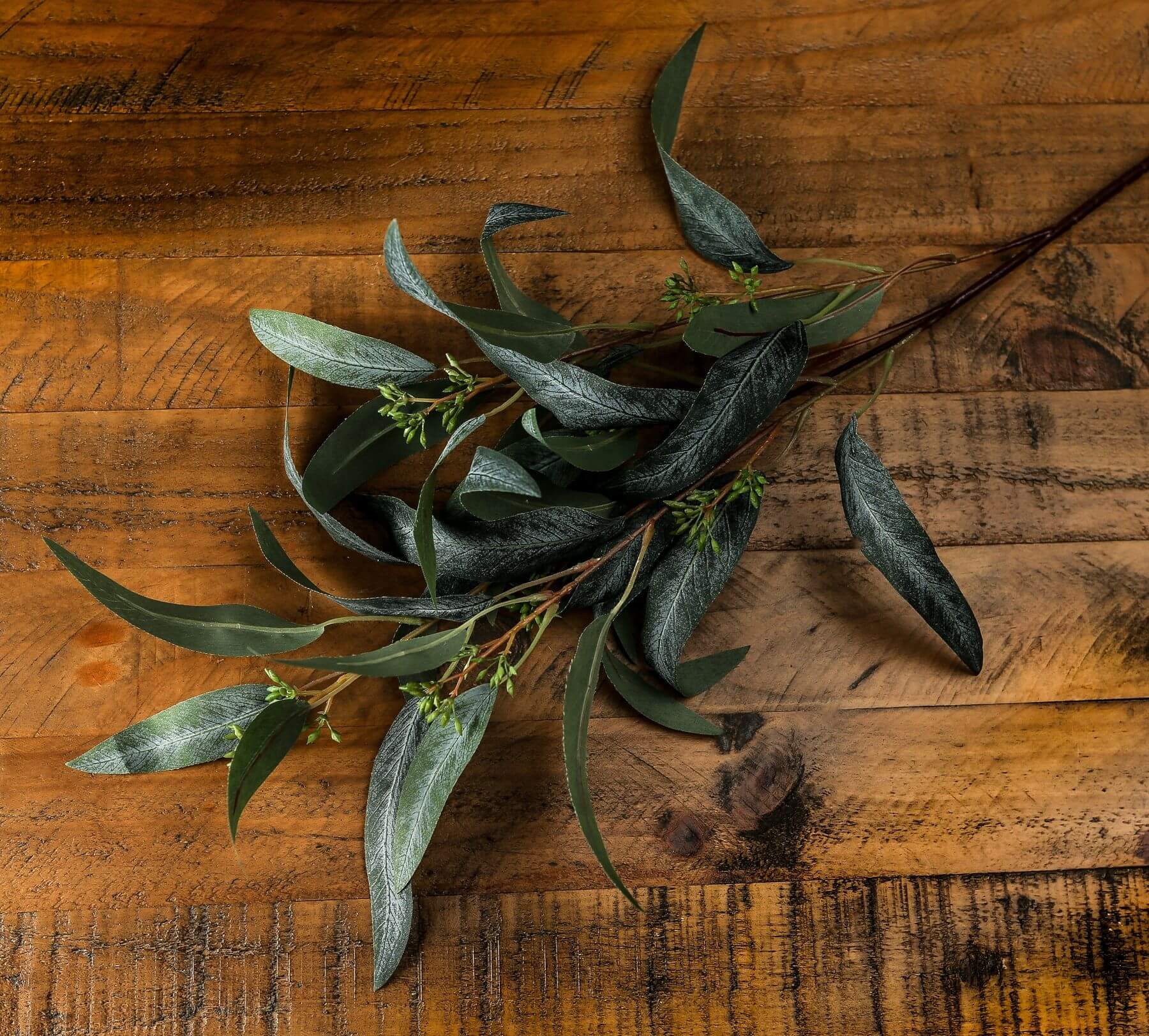 Lifelike seeded eucalyptus spray with natural green leaves and pods, perfect for farmhouse or boho decor arrangements. by Sostter at brixbailey.com