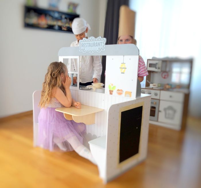 bold front view of the wooden 2-in-1 diner playset in a bright, sunlit playroom