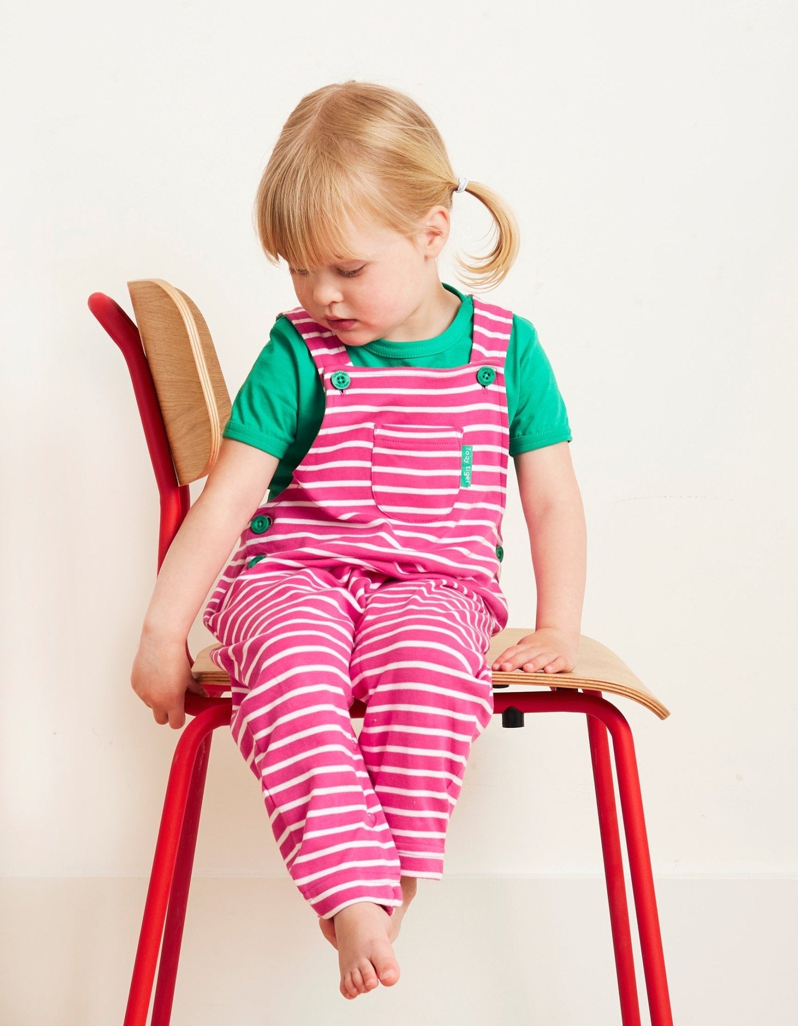 Premium organic cotton striped pinafore overalls, adjustable straps, easy-change snap buttons, stylish pink and white Breton stripes by Toby Tiger at brixbailey.com