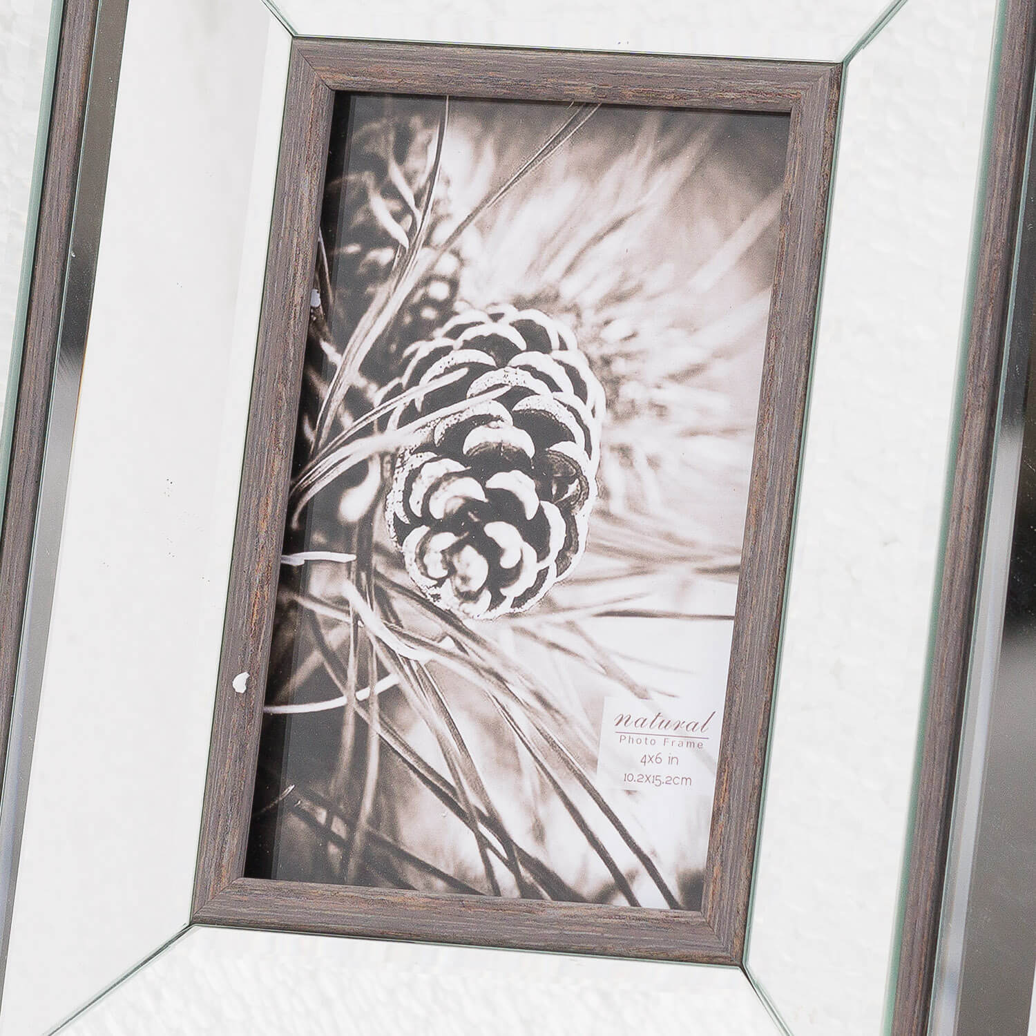 a soft-lit wood and mirror frame on a cozy bedside table, holding a cherished photo