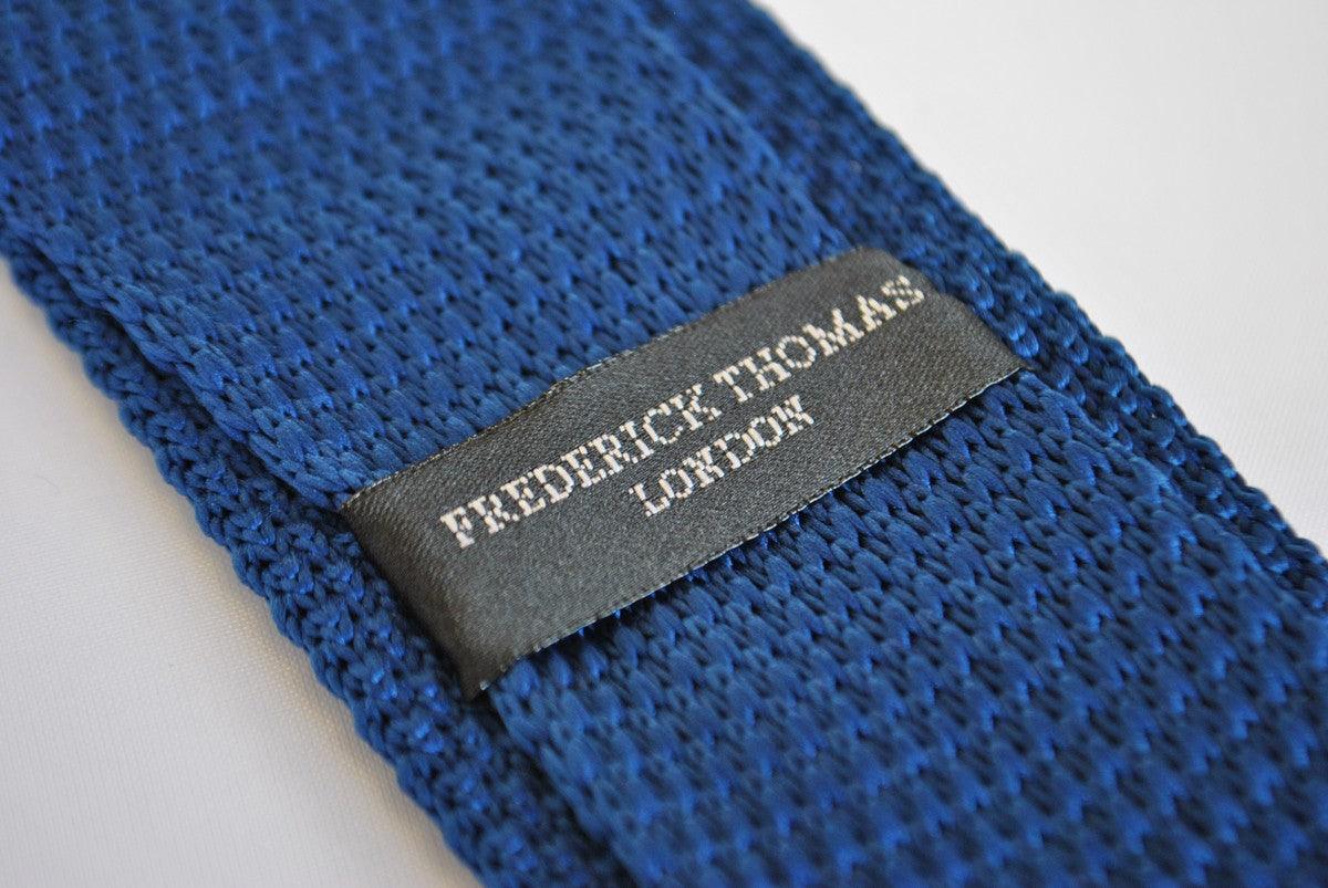 navy blue skinny knitted tie with white polka dots and pointed end