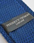 navy blue skinny knitted tie with white polka dots and pointed end