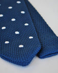 navy blue skinny knitted tie with white polka dots and pointed end
