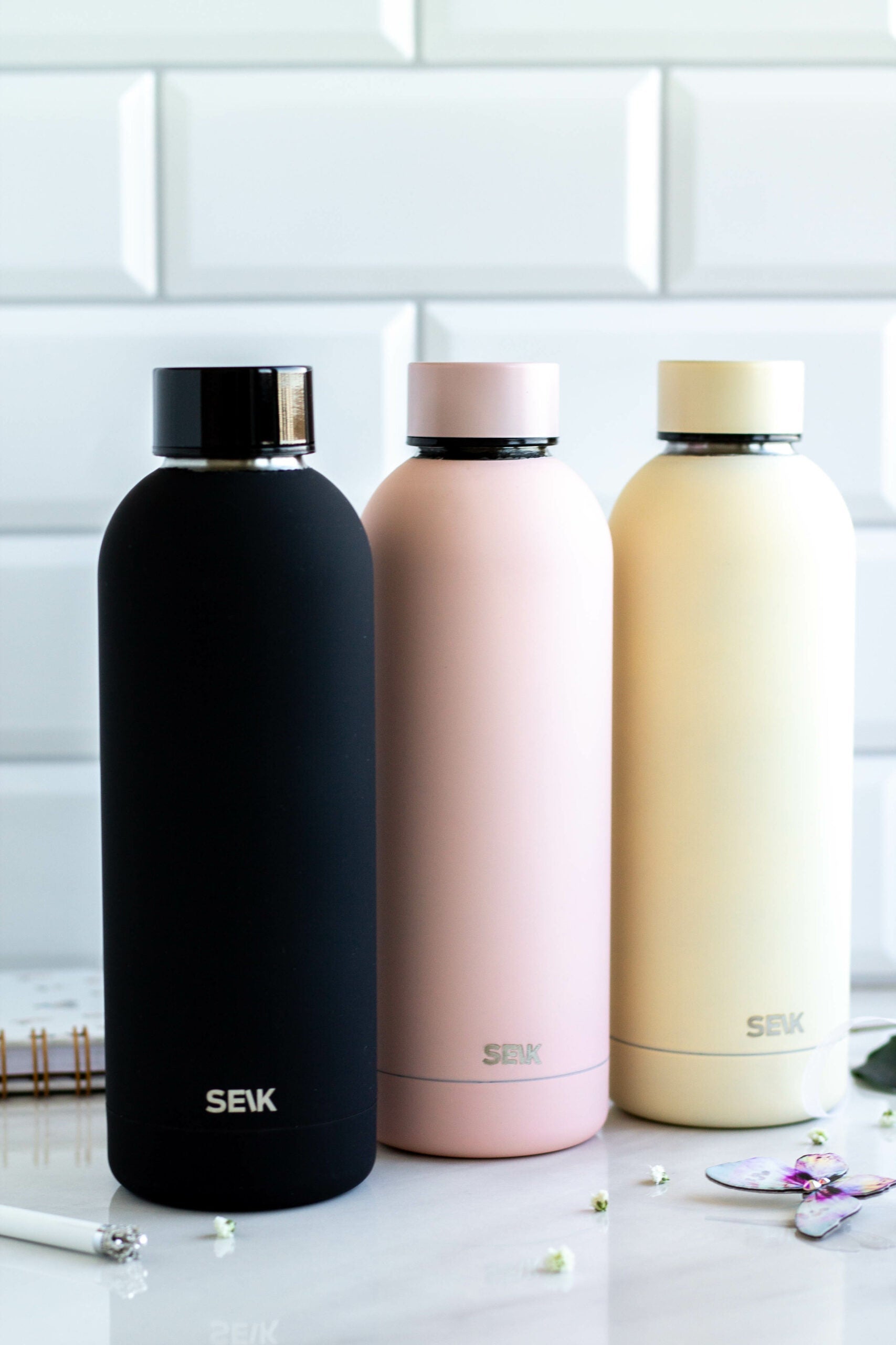 a soft yellow seik thermos bottle held in hand, glowing with warm morning light