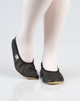 soft black leather gymnastics slippers with a secure rubber edge, resting on a cozy surface