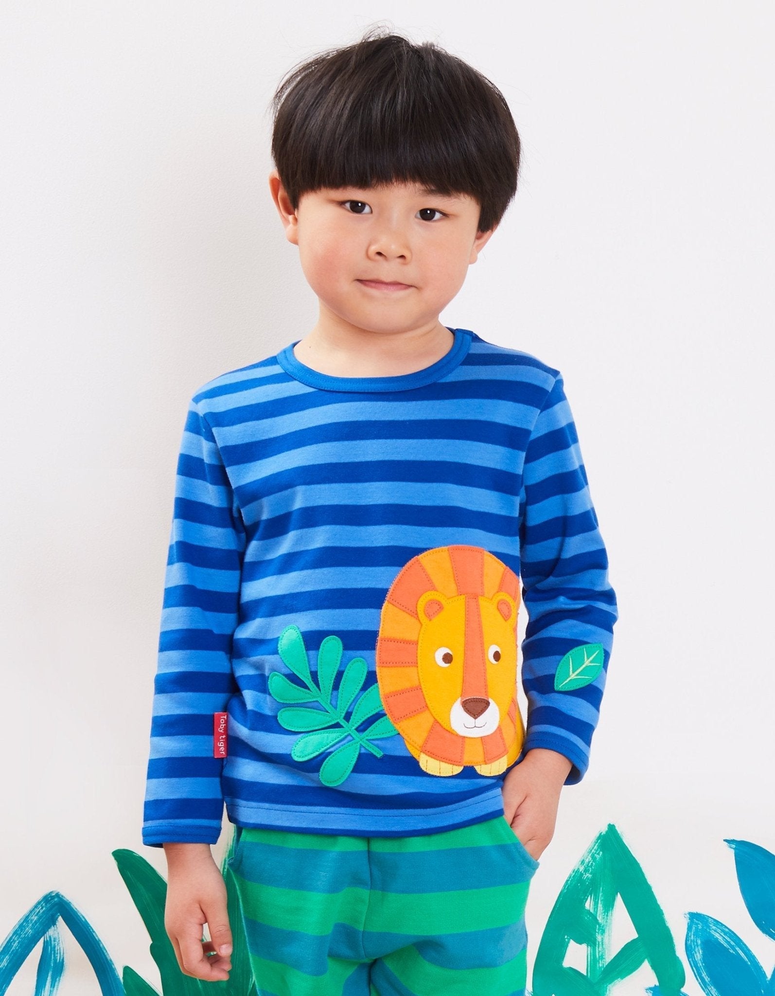 Luxury Organic Cotton Long Sleeve Baby Shirt with Lion Design and Snap Buttons in Blue and Orange Stripes by Toby Tiger at brixbailey.com