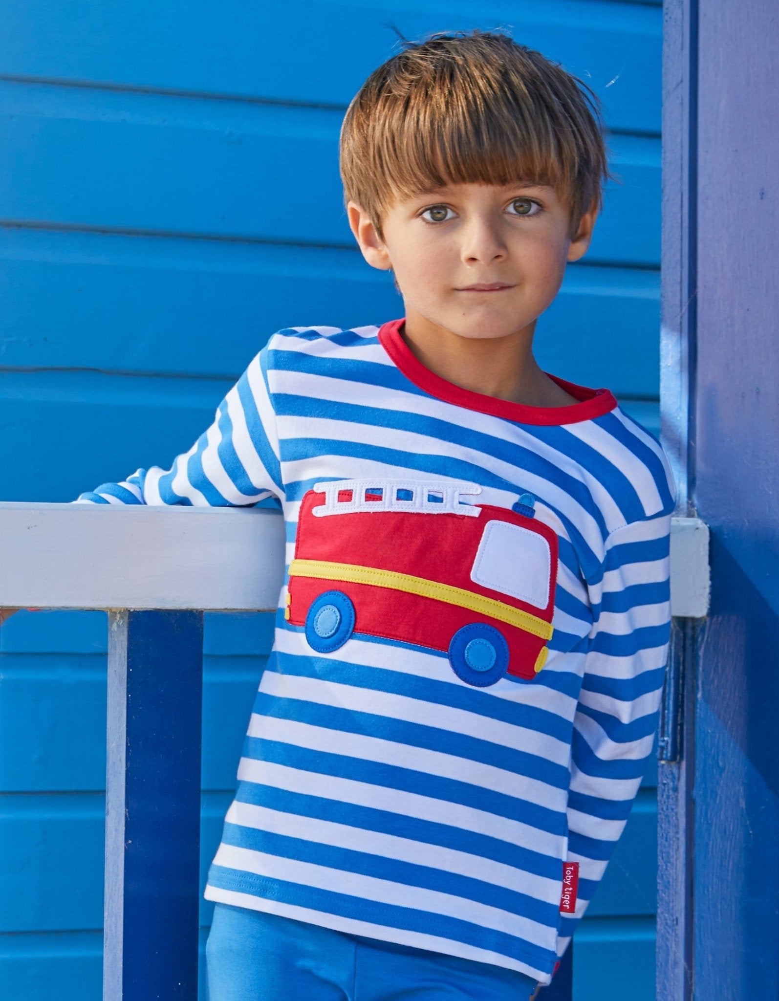 Premium baby long sleeve shirt with fire truck applique, blue and white stripes, red trim, easy-change shoulder snaps, organic cotton by Toby Tiger at brixbailey.com