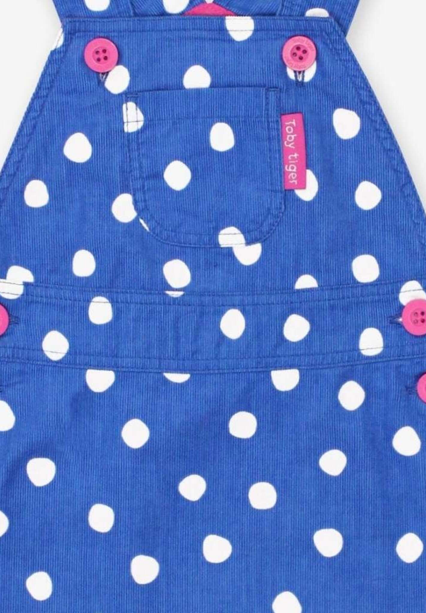 Premium blue corduroy pinafore dress with white polka dots, soft organic cotton, adjustable straps, front pocket, machine washable by Toby Tiger at brixbailey.com