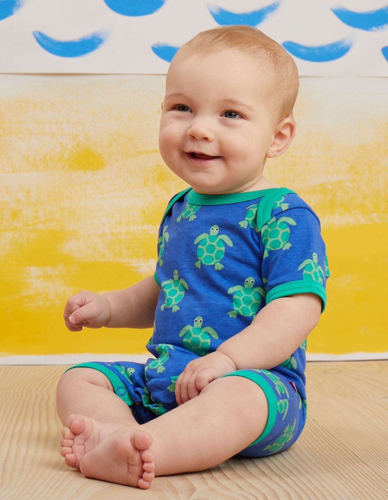 Premium baby summer romper with short legs, cute turtle print, snap buttons, soft organic cotton, easy slip-on neckline by Toby Tiger at brixbailey.com