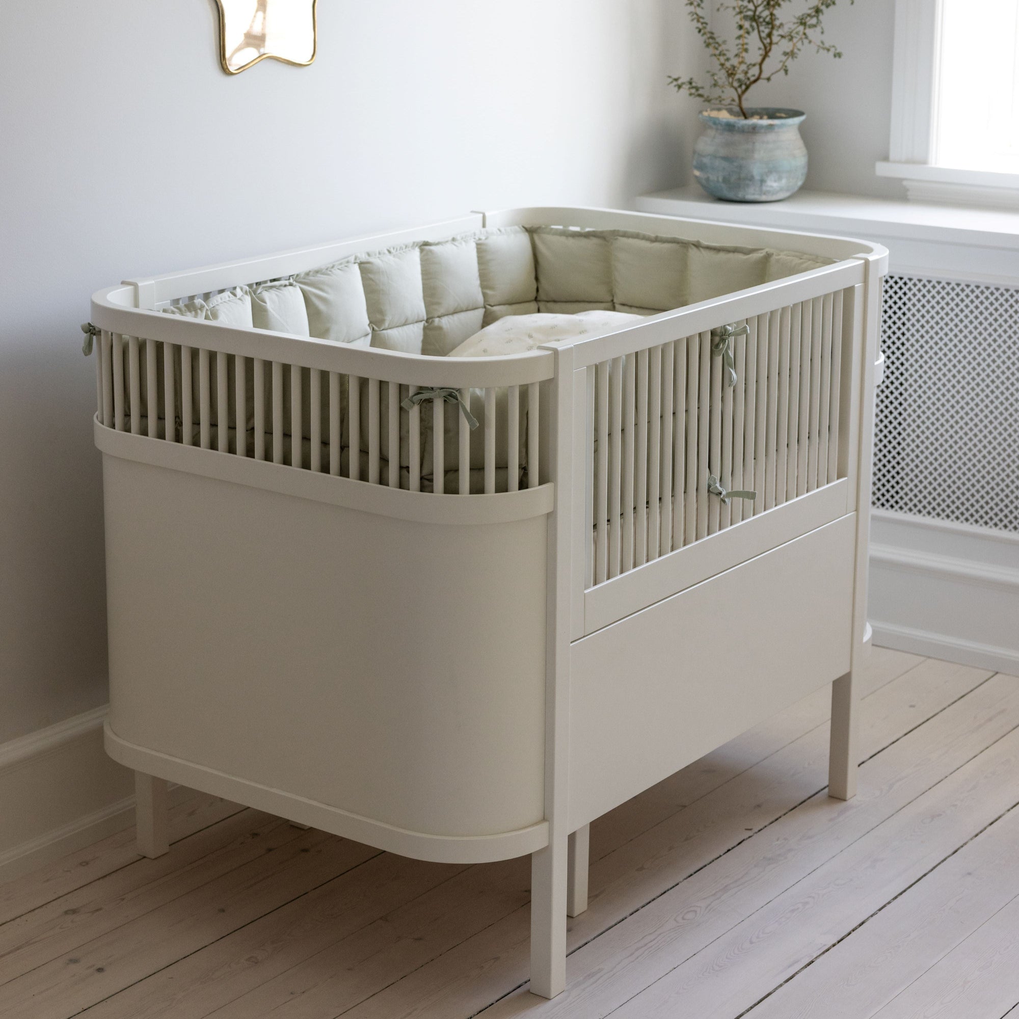 Premium organic cotton kapok bumper in mist green, soft hypoallergenic breathable filling for baby beds, fits standard 60x120cm cribs by Ella James at brixbailey.com