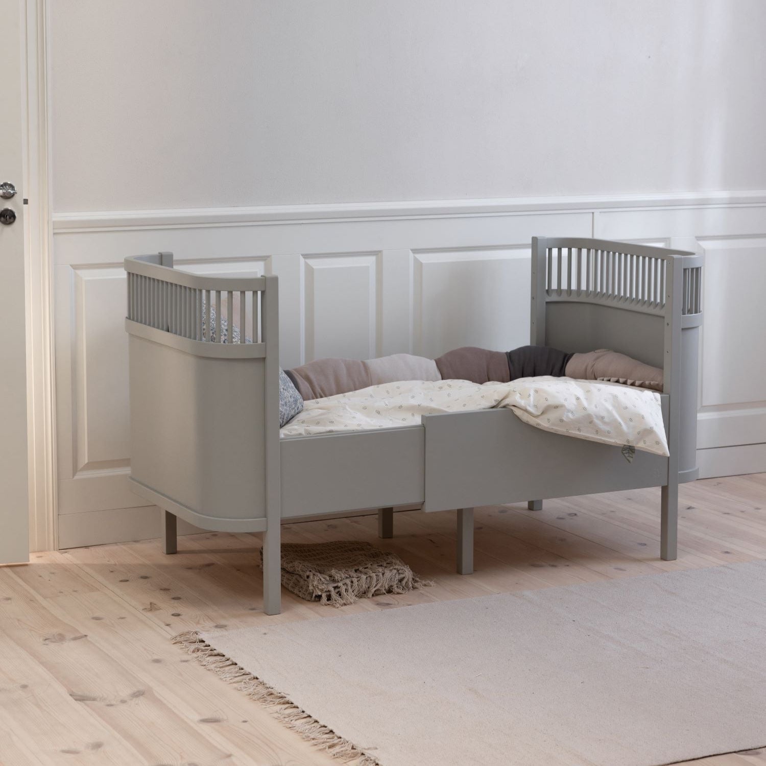 Premium Sebra baby and junior cot bed in stylish stone grey, luxury Nordic beech wood design with adjustable mattress and height-adjustable base by Ella James at brixbailey.com