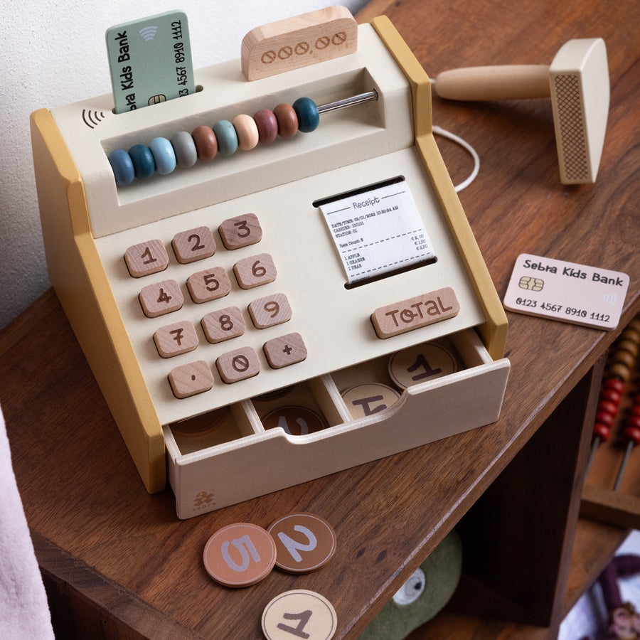 Premium wooden cash register toy, educational play set with coins, scanner, credit cards, and fabric receipt roll by Ella James at brixbailey.com