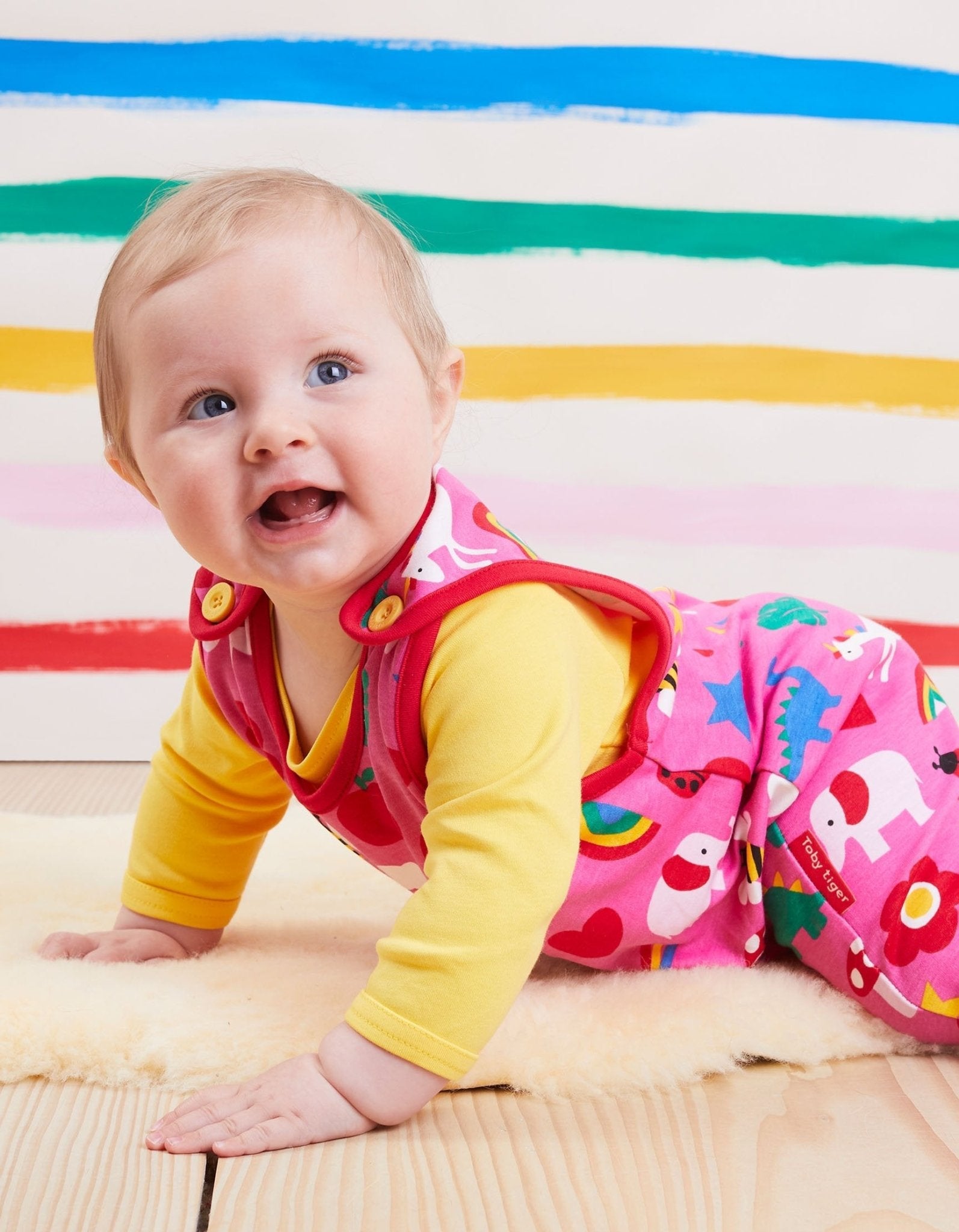 Premium baby romper with colorful dinosaur unicorn elephant print, organic cotton short sleeve bodysuit, easy-change snap buttons, soft sustainable fabric by Toby Tiger at brixbailey.com