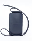 bold navy leather phone bag with gold hardware on a model, showcasing its confident crossbody style