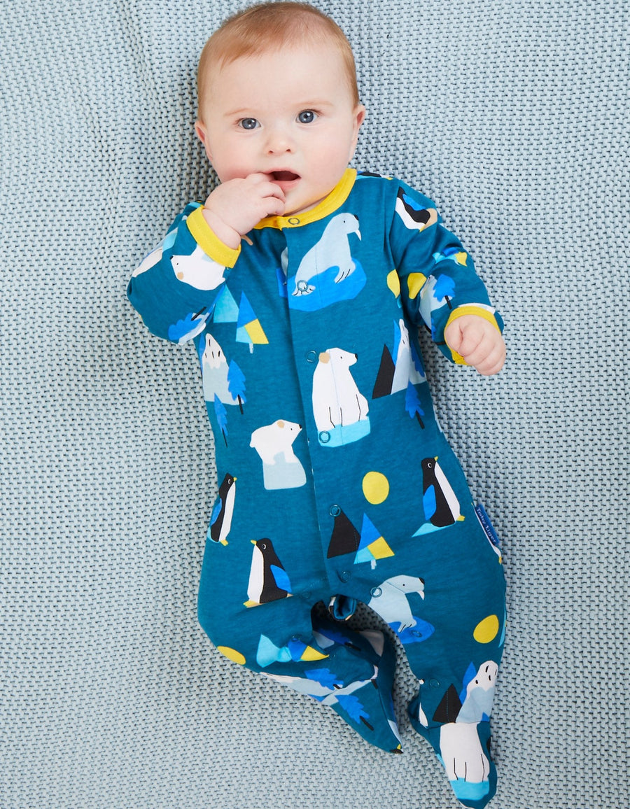 Premium blue organic cotton baby pajamas with penguins, walruses, polar bears, and Arctic print, soft yellow trim, snap buttons, footed design by Toby Tiger at brixbailey.com