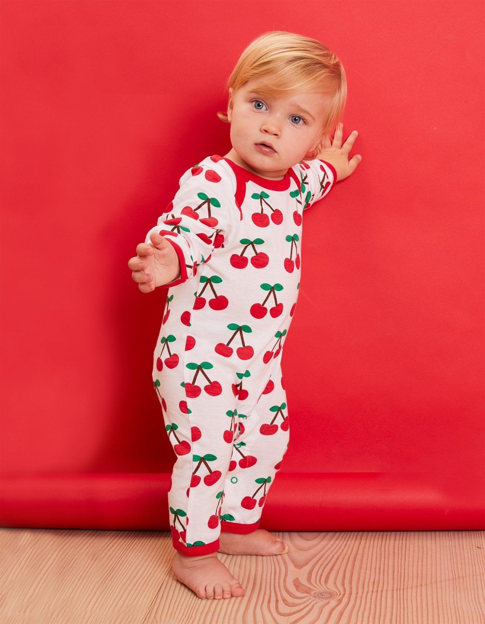 Premium organic cotton pajamas with cherry print, stylish red trim, slip-on neckline, snap buttons, soft GOTS-certified fabric by Toby Tiger at brixbailey.com