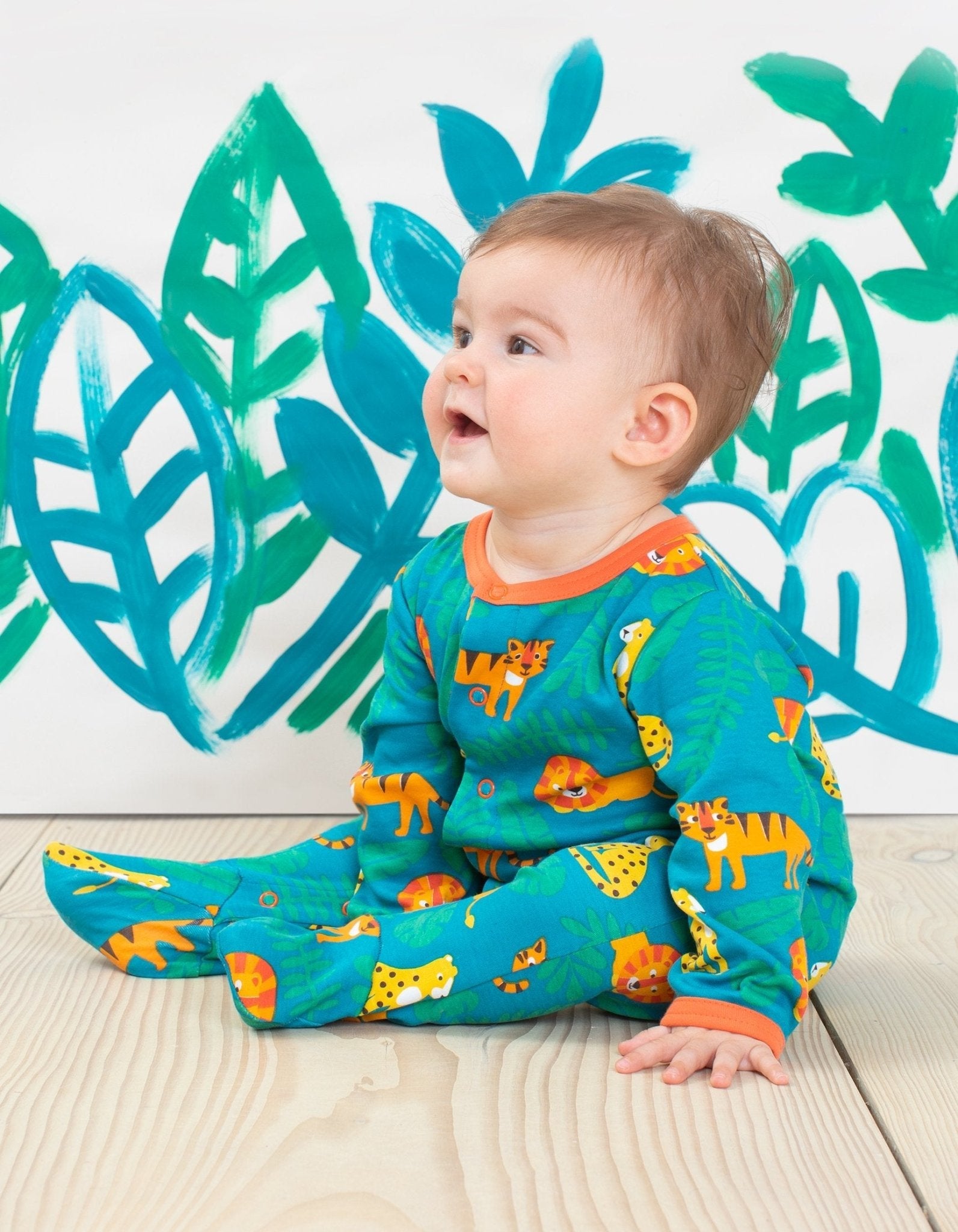 Premium baby sleepwear with lion print, 100% organic cotton, soft and comfortable, fully buttoned for easy diaper changes, GOTS certified by Toby Tiger at brixbailey.com