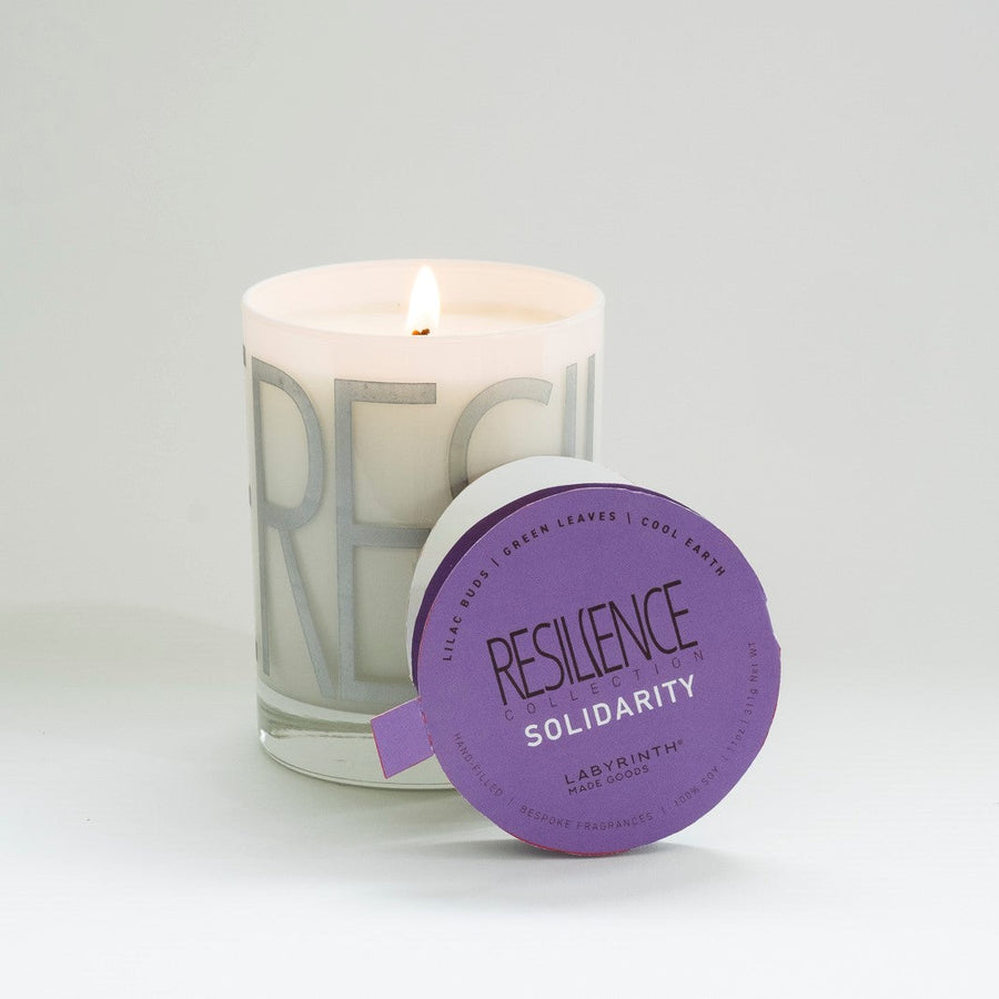 Luxury Solidarity soy candle with lilac buds, green leaves, cool earth scent, handcrafted premium fragrance, 60-hour burn time by Labyrinth Made Goods at brixbailey.com