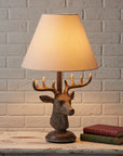 Decorative table lamp with deer head design on a reflective surface from brixbailey.com