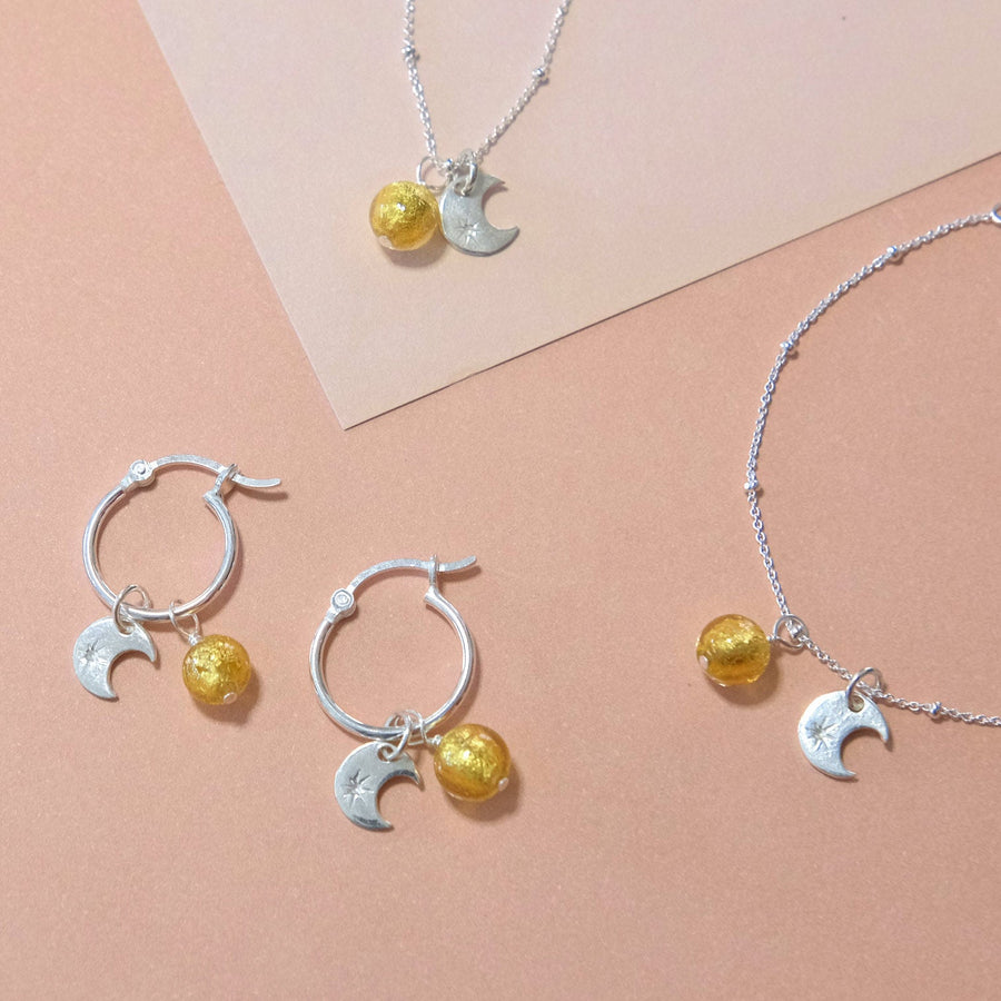 Luxury sterling silver sun and moon earrings with Murano glass charm, stylish hoops for day to night by Lezzeri at brixbailey.com